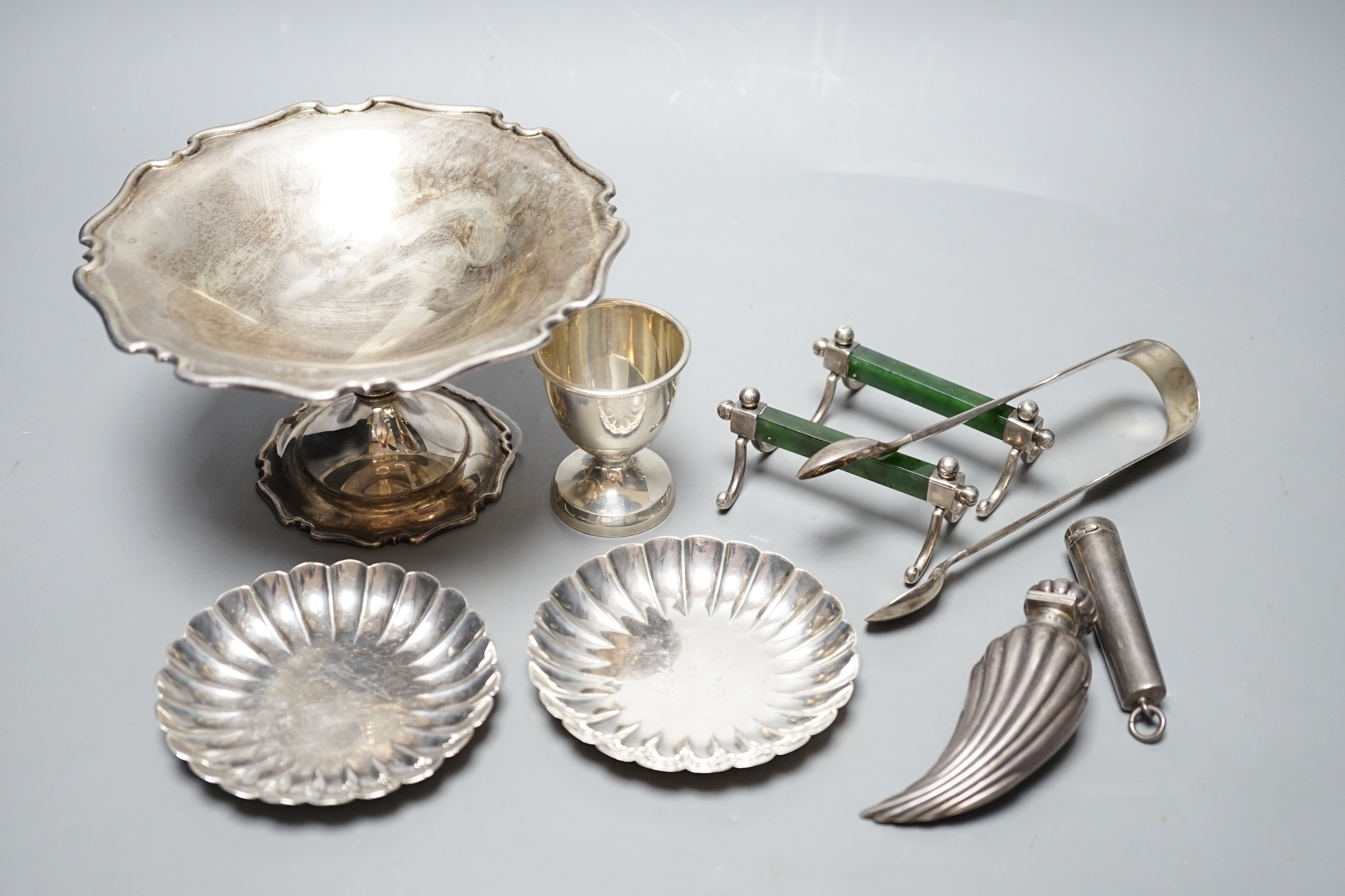 A George V silver tazze, diameter 14.7cm, two small sterling nut dishes, a late Victorian fluted silver scent bottle, of curved form, Horton & Allday, Birmingham, 1889, a pair of silver and nephrite mounted knife rests,